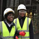 Two young people in high vis jackets and hard hats