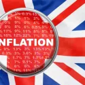 UK flag background with a magnifying glass on the word inflation in the foreground