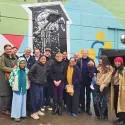 Group of people in front of colourful mural