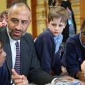 Matthew Ryder sits at table and speaks with students