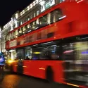 A bus on a London road at night