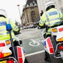 Policemen on motorbike waiting at red light. 	© Martin Breschinski