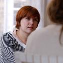 Two women sat in chairs having a conversation