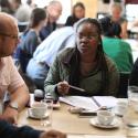 A group of people sit around a table having a discussion