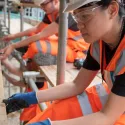 Three people work from scaffolding on Ladywell's SelfBuild Community space