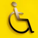 Person on wheelchair icon on yellow background