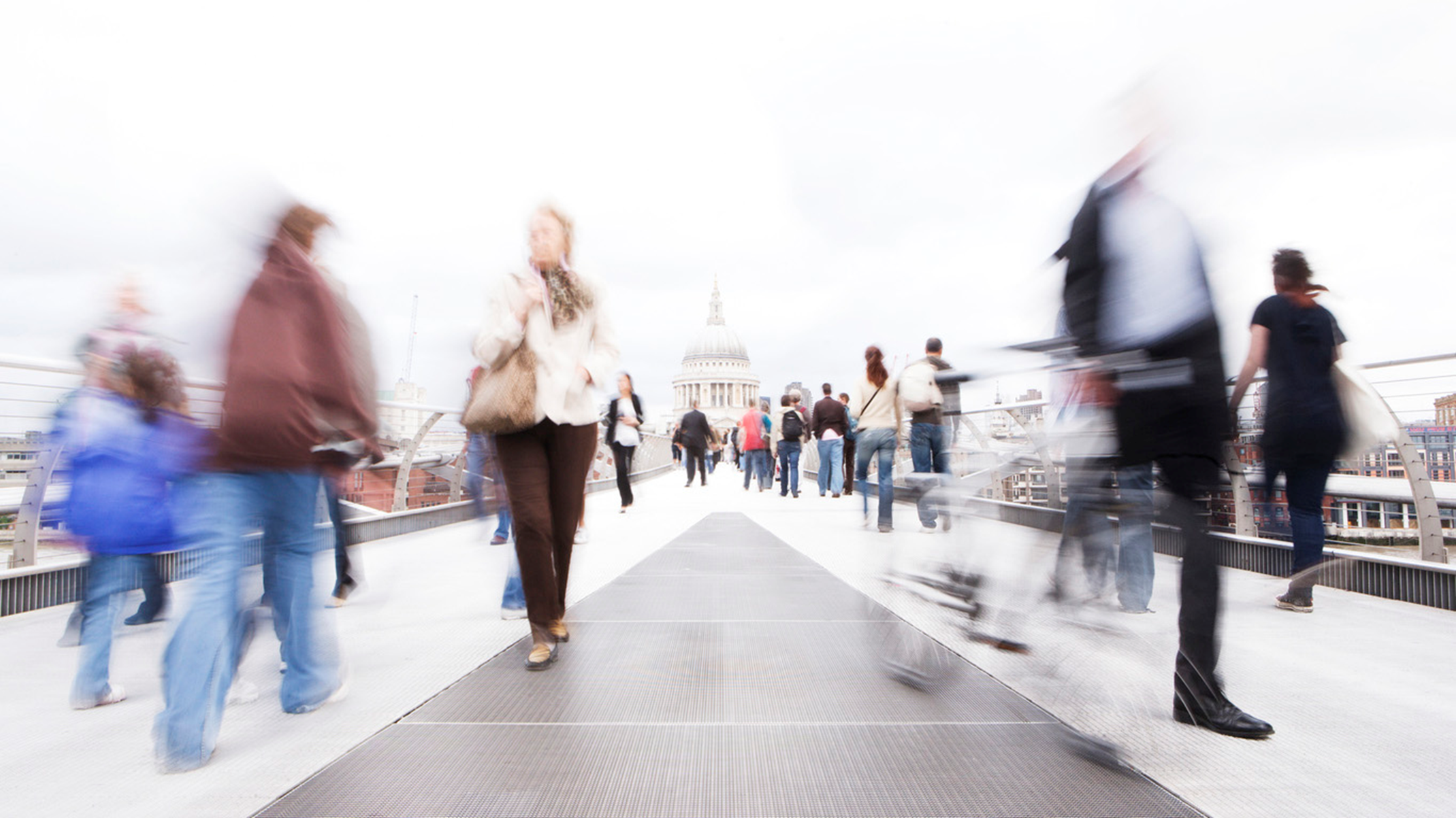 A crowd of people walking over Millennium bridge