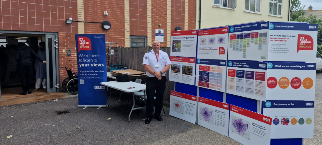 London Fire Brigade officer standing near a table with information about LFB