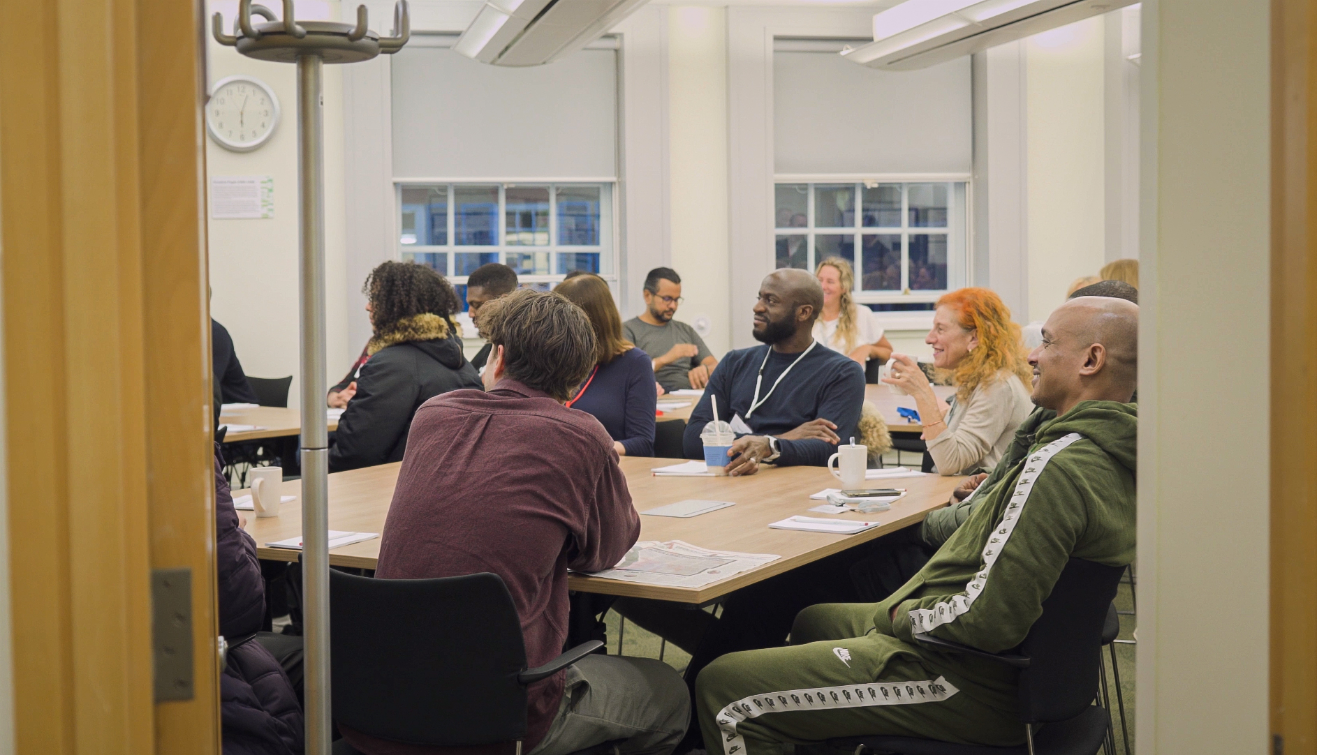 A group of people sitting at tables listening to a presentation