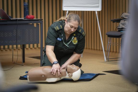 A female member of the London Ambulance Service is performing CPR on a doll as part of a training course on lifesaving skills.