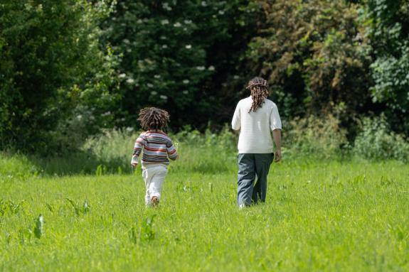 A dad and his child exploring a green field