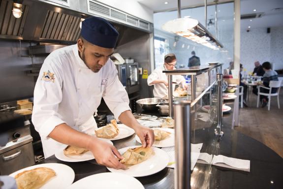 A young chef plating up a dish