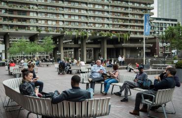 People sitting on benches outside the Barbican
