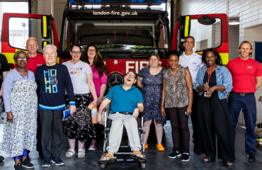 A group of Londoners posing in front of a red fire engine 