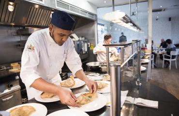 A young chef plating up a dish